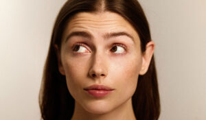 Frau mit markanten Augenbrauen runzelt die Stirn